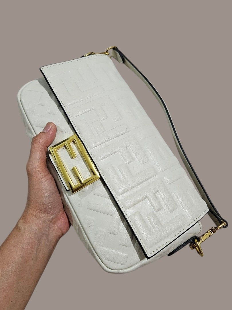 Fendi Embossed Baguette Bag (Category: Shoulder Bags) located in Caloocan City. Submitted by zoetormojal.18d615 (Listing ID 1466023331, Image 3). Description: Fendi White Embossed Leather Baguette Bag - Genuine nappa leather - Embossed FF logo pattern - Gold FF buckle closure - Genuine leather material - Single top handle - Chic and stylish design - Thrifted in Dubai - H 6" x L 10" x D 2.5" Inches - NO Issue all intact just like new condition - P