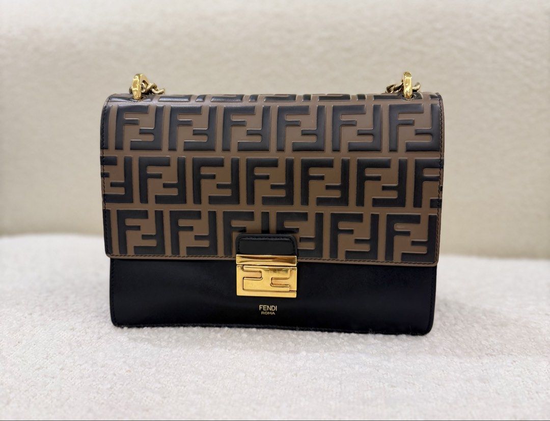 Fendi Kan U Shoulder Bag (Category: Luxury Bags & Wallets) located in San Juan City. Submitted by the_gracious_life (Listing ID 1466046001, Image 3). Description: - Brand: Fendi - Style: Shoulder Bag - Material: Brown and black leather with embossed FF monogram - Hardware: Gold-tone throughout, featuring the Fendi Roma logo under the clasp - Strap: Dual chain strap with comfortable leather shoulder pad - Interior: Two compartments divided by a pa