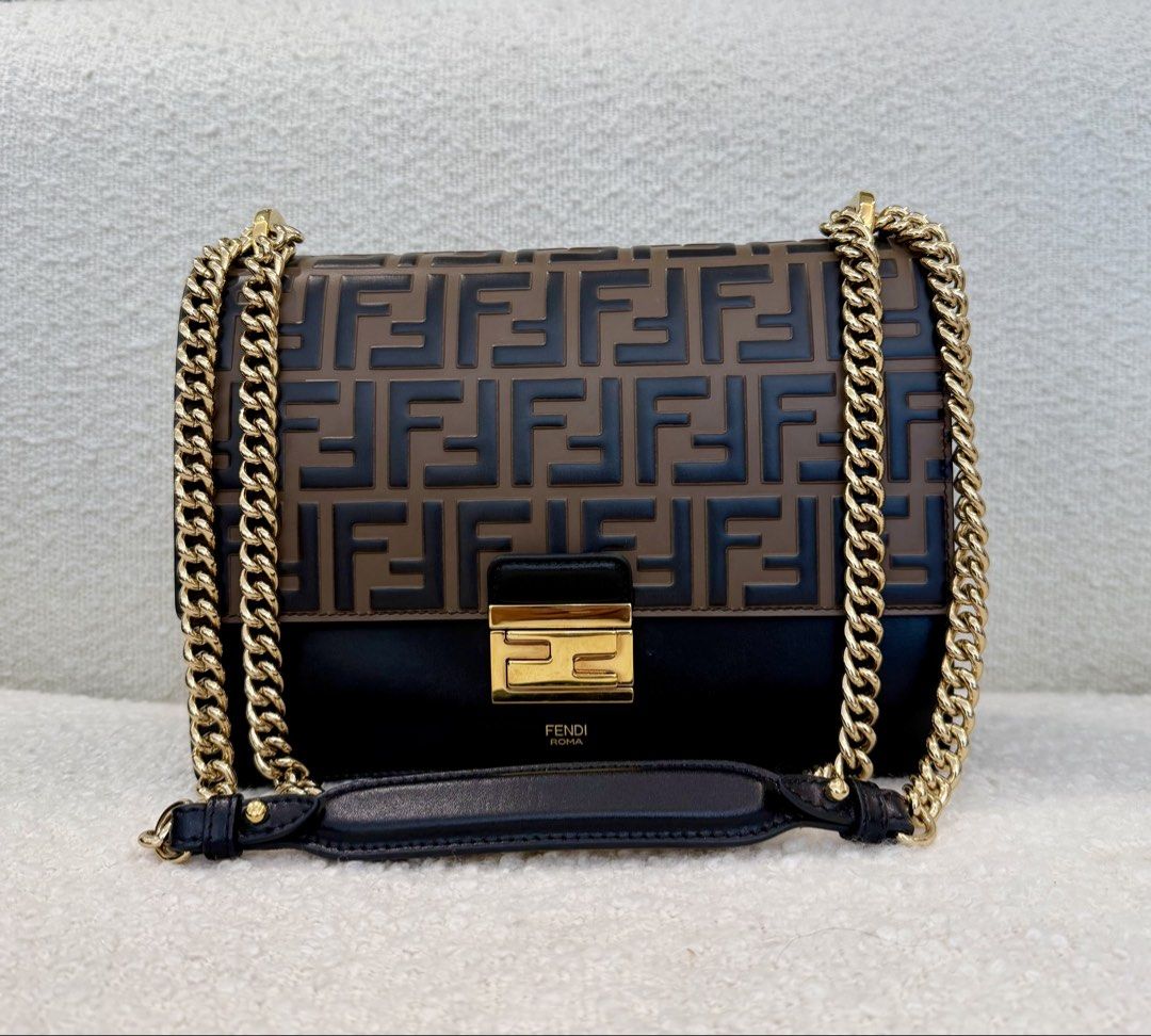 Fendi Kan U Shoulder Bag (Category: Luxury Bags & Wallets) located in San Juan City. Submitted by the_gracious_life (Listing ID 1466046001, Image 2). Description: - Brand: Fendi - Style: Shoulder Bag - Material: Brown and black leather with embossed FF monogram - Hardware: Gold-tone throughout, featuring the Fendi Roma logo under the clasp - Strap: Dual chain strap with comfortable leather shoulder pad - Interior: Two compartments divided by a pa