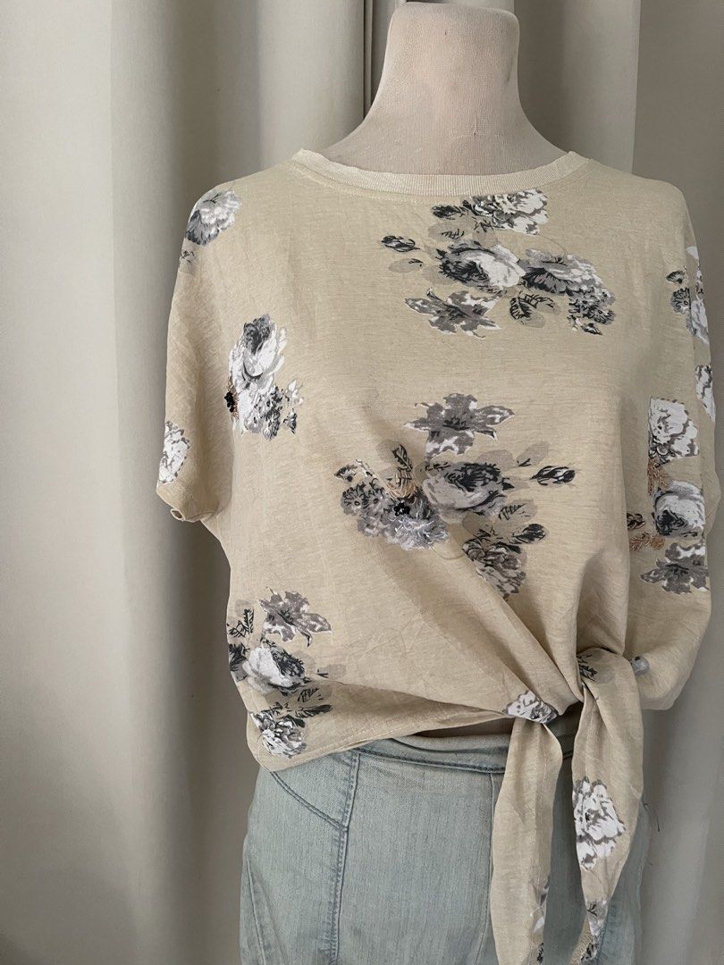 Floral Print Front Tie Short Sleeve Top (Category: Blouses) located in Cainta. Submitted by zlove111 (Listing ID 1466109519, Image 2). Description: - Color/Pattern: Beige with black and white floral print - Fit: Relaxed, loose fit with a round neckline - Design: Built-in front hem tie knot - Material: Soft and comfortable cotton blend - Styling: Perfect to pair with denim shorts or jeans for a casual weekend look med - large semi crop .