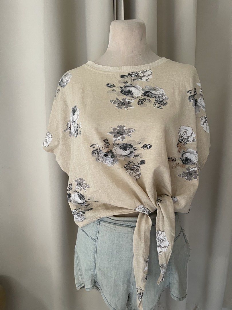 Floral Print Front Tie Short Sleeve Top (Category: Blouses) located in Cainta. Submitted by zlove111 (Listing ID 1466109519, Image 1). Description: - Color/Pattern: Beige with black and white floral print - Fit: Relaxed, loose fit with a round neckline - Design: Built-in front hem tie knot - Material: Soft and comfortable cotton blend - Styling: Perfect to pair with denim shorts or jeans for a casual weekend look med - large semi crop .