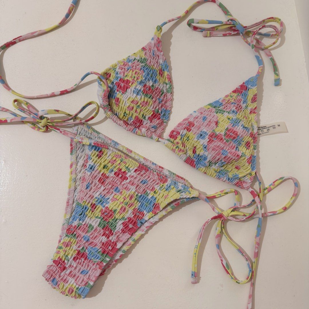 Floral Smocked Bikini Set (Category: Bikinis & Swimsuits) located in Cebu City. Submitted by softly.preloved (Listing ID 1466153353, Image 1). Description: - no issues. Used only twice -size: M (tag attached) but adjustable ties so it can fit small - colorful floral print (yellow, pink, blue) with a trendy smocked texture - top: triangle style with adjustable ties - bottoms: matching tie-side design with moderate coverage .