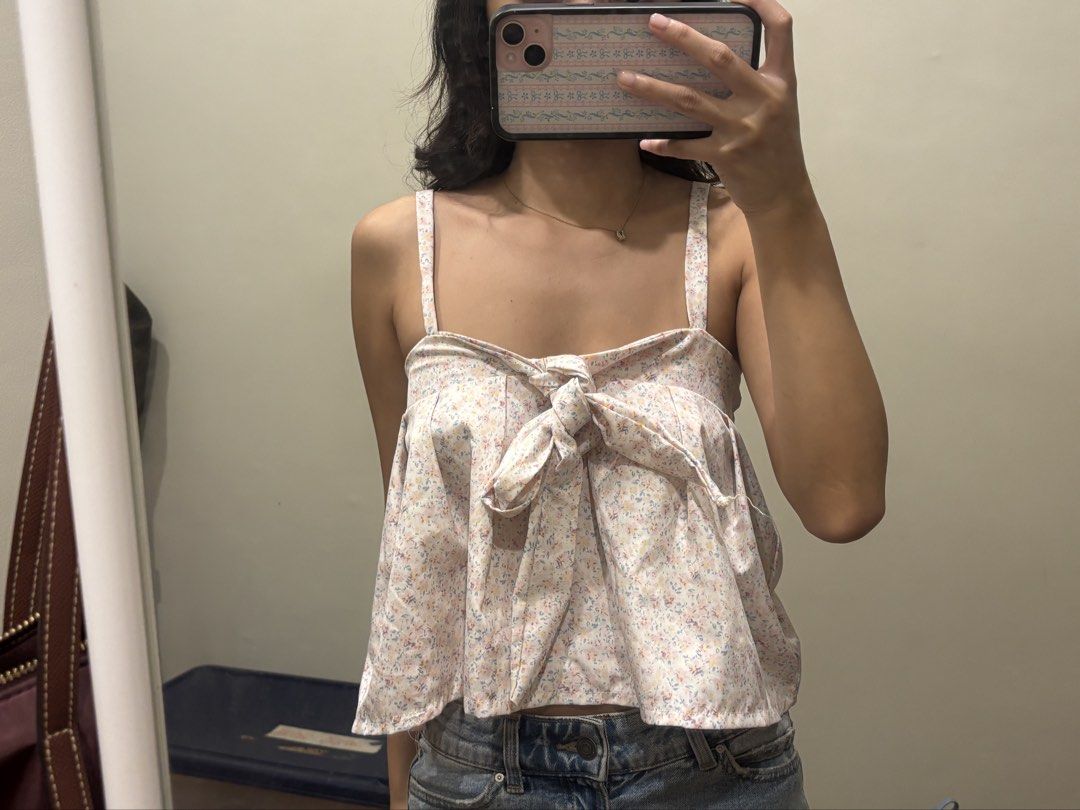 Floral spaghetti strap tank top with front bow (Category: Sleeveless) located in Paranaque City. Submitted by domisclosett (Listing ID 1466089810, Image 2). Description: - Style: Floral print cami top with a light pink background and tiny blue/yellow flowers - Details: Front tie knot at the bust and a flowy, flared hemline - Comfort: Elastic band across the upper back for extra stretch and easy wear loc: parañaque/muntinlupa area mop: gcash, mari