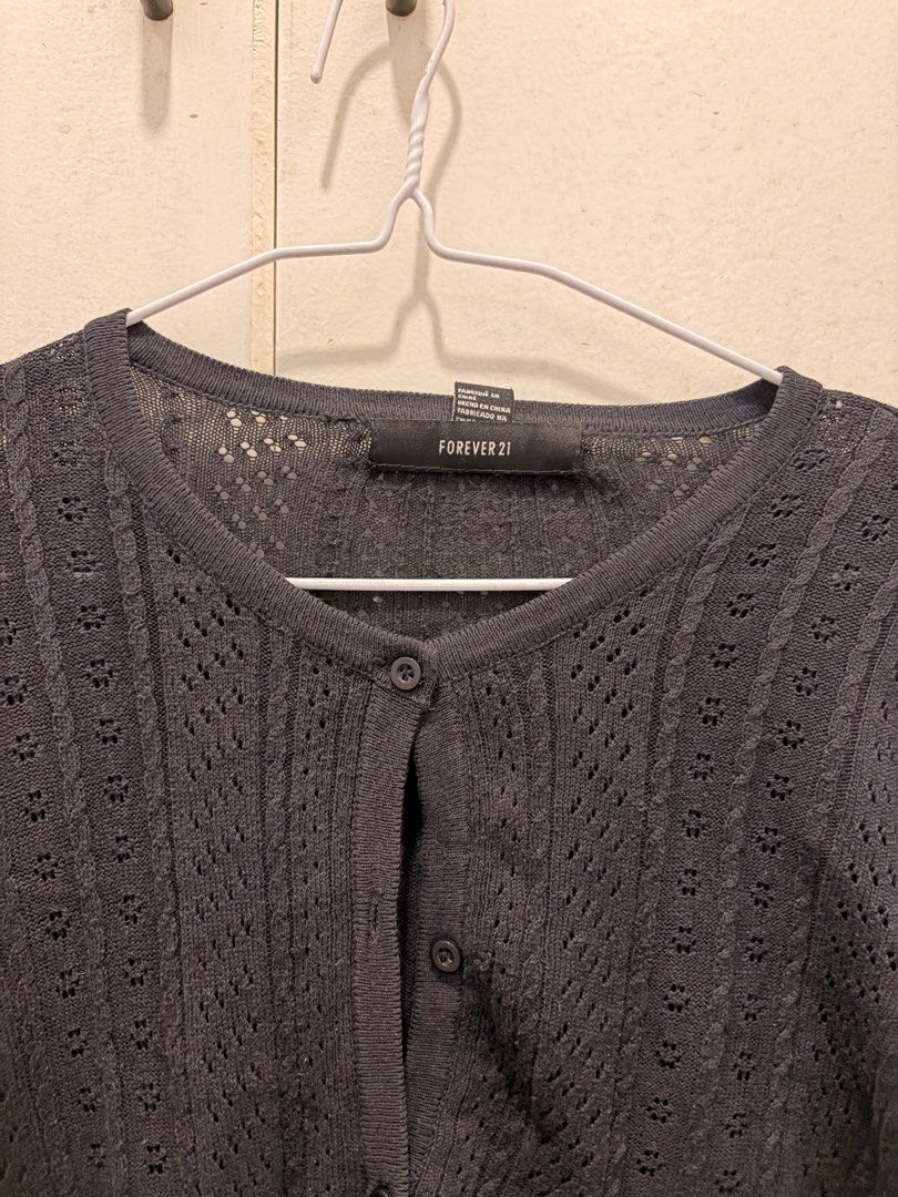 Forever 21 Black Knit Cardigan (Category: Coats, Jackets and Outerwear) located in Pasay City. Submitted by notellyyyy (Listing ID 1465993494, Image 2). Description: - Brand: Forever 21 - Color: Classic Black - Material: Lightweight knit with textured pattern - Fit: Standard fit, neckline sits below the collarbone - Features: Button-down front and long sleeves - Styling: Perfect for easy layering over tops and dresses.