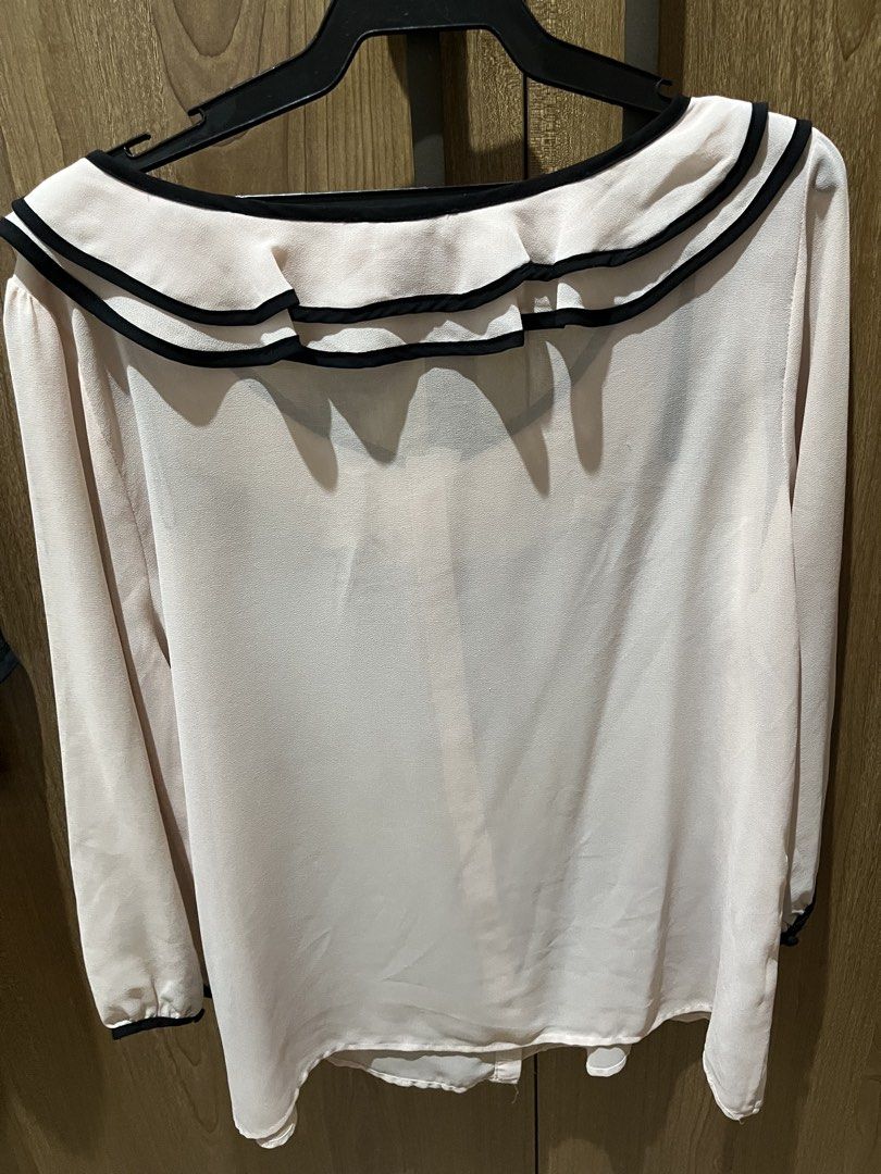 Forever 21 Ruffle Collar Blouse Size L (Category: Blouses) located in Quezon City. Submitted by epictiger.c6451a (Listing ID 1465963760, Image 2). Description: - Brand: Forever 21 - Size: L (tag attached) - Color: Light pink with black trim - Design: Double ruffle collar, button-up front, long sleeves with trimmed cuffs - Material: Lightweight fabric - Origin: Made in China - Condition: Excellent/Ready to wear - Versatility: Perfect for both work