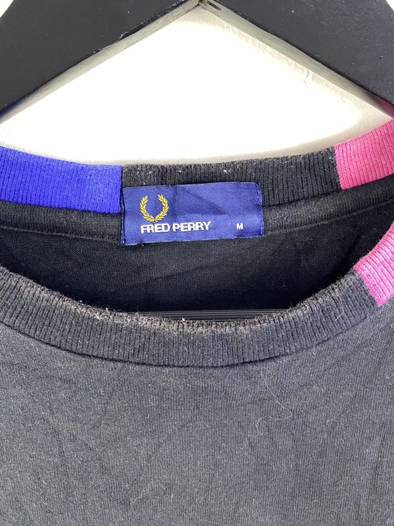 Fred Perry Black T-Shirt Size M (Category: Tshirts & Polo Shirts ) located in Manila. Submitted by declutterpromax (Listing ID 1466018277, Image 2). Description: - Brand: Fred Perry - Color: Black with pink and blue collar trim - Details: Blue embroidered laurel wreath logo on chest - Size: Medium (tag inside) - Origin: Made in China - Measurements: 20 inches pit to pit, 26 inches length - Style: Classic casual tee.