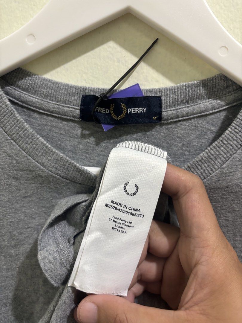 Fred Perry Grey T-Shirt Size M M8529 (Category: Tshirts & Polo Shirts ) located in Daraga. Submitted by hannieldustin (Listing ID 1466063410, Image 3). Description: - Brand: Fred Perry - Style/Model Code: M8529 - Color: Grey - Size: Medium - Condition: Brand new with tags attached - Design Details: Ribbed crew neck, short sleeves with maroon and dark blue striped cuffs, and embroidered laurel wreath logo on the chest - Origin: Made in China - 19.