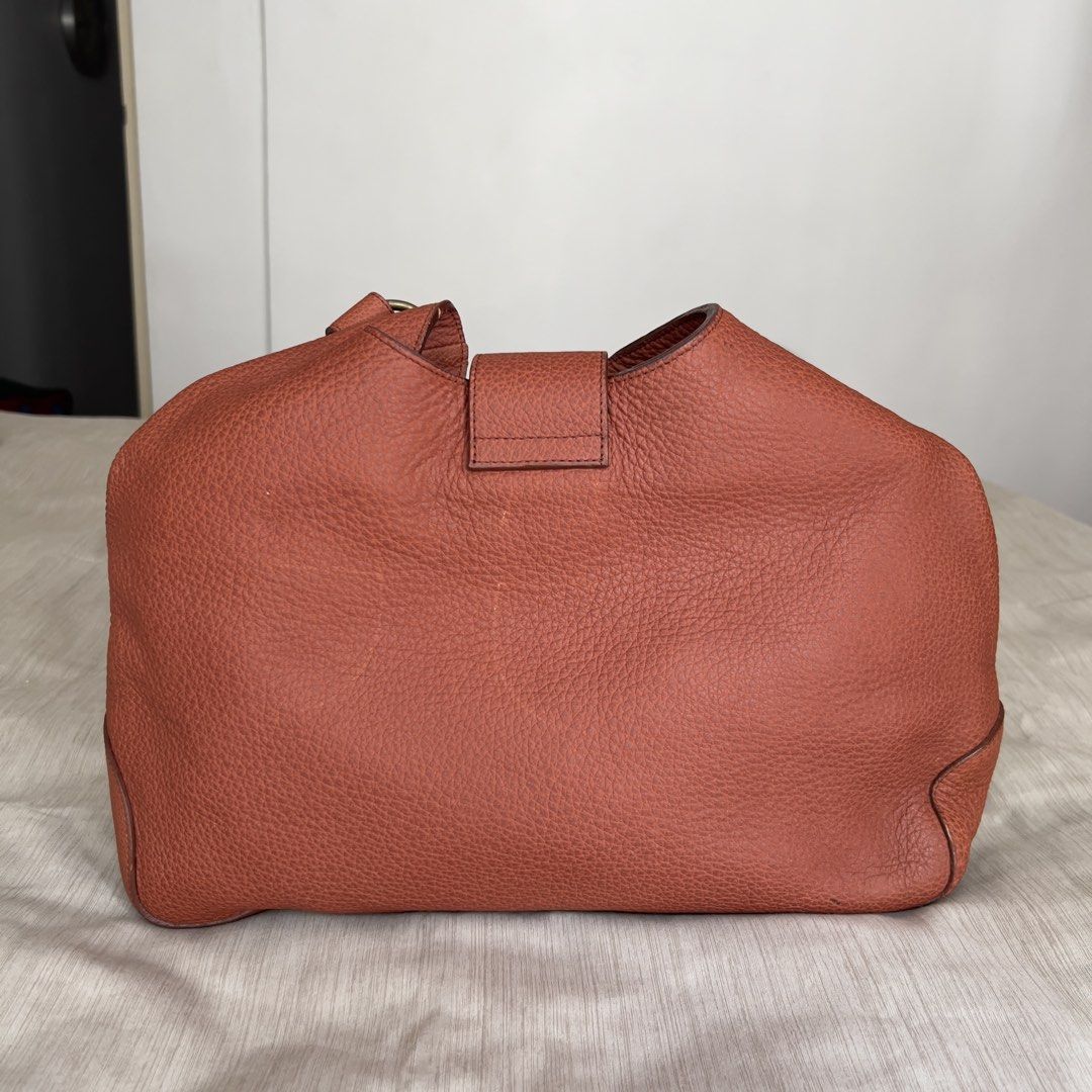 Genuine Leather Hobo Shoulder Bag (Category: Shoulder Bags) located in Pasig City. Submitted by jenscloset86 (Listing ID 1465986611, Image 2). Description: Measurement (in inches): Length: 10.5” Height: 5” Strap: 20” • Brown pebbled genuine leather with brass hardware. • Structured base with a stylish slouchy top • Includes an adjustable strap with ring attachments • Flaw: Minor scuff mark near the bottom front (barely noticeable)..