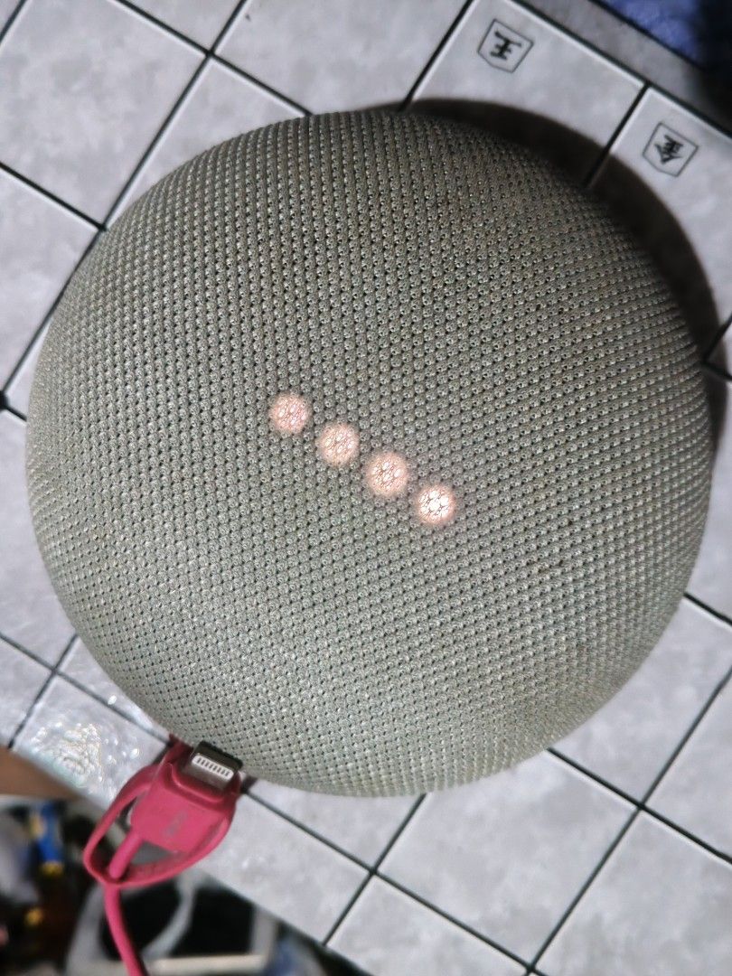 Google Home Mini Smart Speaker (Category: Soundbars, Speakers & Amplifiers) located in San Jose del Monte. Submitted by toys.merch.electronic (Listing ID 1466104173, Image 3). Description: - Authentic Google Home Mini in Sage Green fabric mesh - Orange rubber base with Google logo - Tested and fully working (powers on with 4 indicator lights) - Compact size, perfect for voice control and casual music streaming - Flaw: Small dark mark on the side 