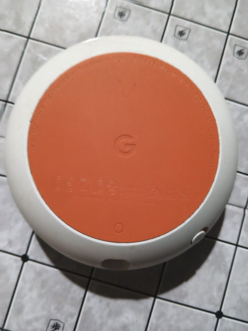 Google Home Mini Smart Speaker (Category: Soundbars, Speakers & Amplifiers) located in San Jose del Monte. Submitted by toys.merch.electronic (Listing ID 1466104173, Image 2). Description: - Authentic Google Home Mini in Sage Green fabric mesh - Orange rubber base with Google logo - Tested and fully working (powers on with 4 indicator lights) - Compact size, perfect for voice control and casual music streaming - Flaw: Small dark mark on the side 