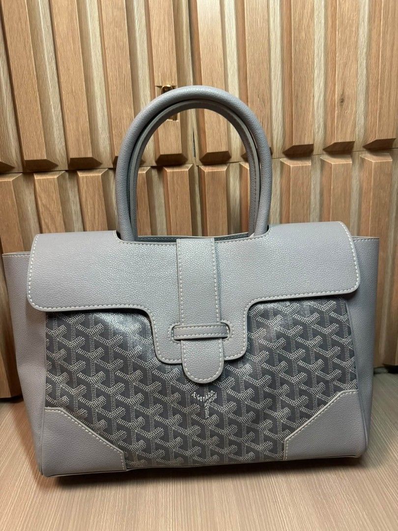 Goyard Saumur Grey Tote Bag (Category: Luxury Bags & Wallets) located in Manila. Submitted by goodbuying_items0211 (Listing ID 1466124255, Image 1). Description: Grey leather tote with Goyard monogram canvas panels. Wooden accent bar across the back. Structured top handle design with a front flap closure and buckle strap. Clean stitching throughout. Sturdy grey handles and reinforced corner patches..