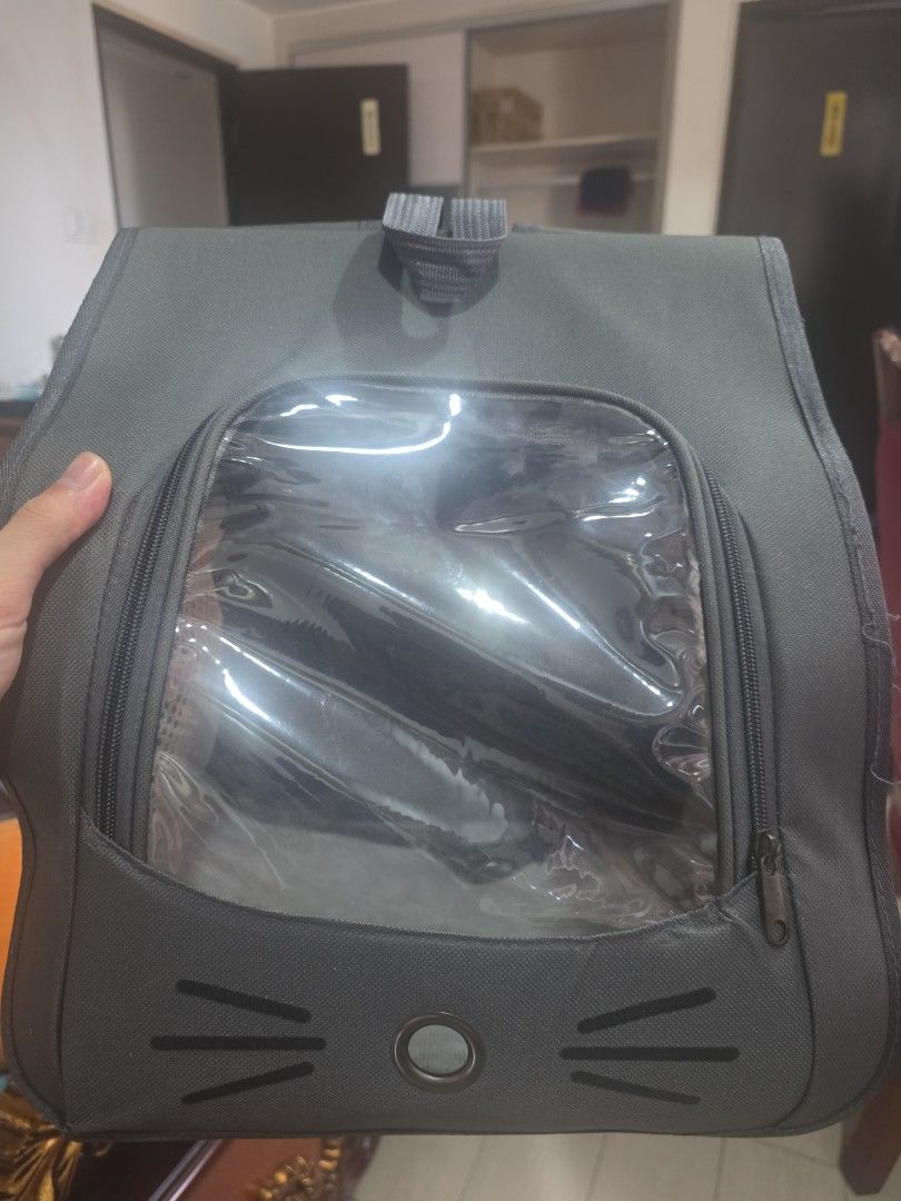 Grey Pet Backpack Carrier with Clear Window and Mesh (Category: Homes & Other Pet Accessories) located in Manila. Submitted by read_description (Listing ID 1465984618, Image 1). Description: - Color: Grey - Suitable for cats and small dogs - Clear front window with adorable whisker embroidery details - Breathable mesh panels for optimal ventilation - Secure all-around zipper closure - Safe and convenient for traveling with your pet.