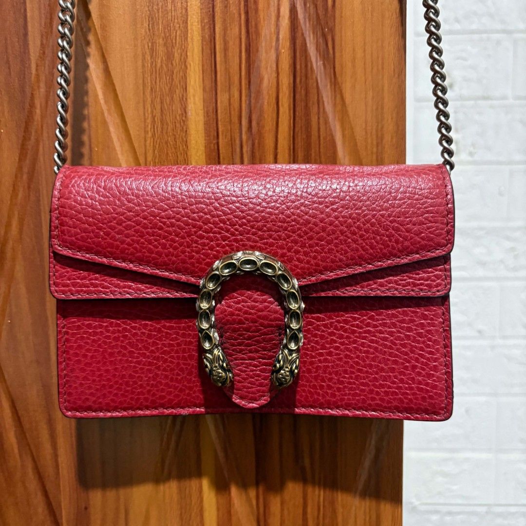 Gucci Dionysus Super Mini Leather Bag Red (Category: Luxury Bags & Wallets) located in Carmen. Submitted by ar_thrift00 (Listing ID 1466087757, Image 2). Description: - Gucci red textured leather bag - Signature antique silver-toned tiger head horseshoe closure - Removable chain shoulder strap for versatile styling - Magnetic snap button closure with engraved Gucci lettering - Structured accordion sides with a clean red interior lining - Compact 