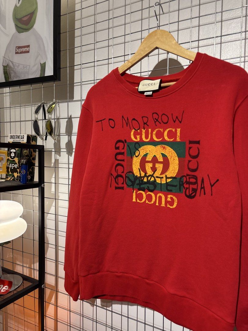 Gucci 'Tomorrow is Yesterday' Red Sweatshirt (Category: Coats, Jackets and Outerwear) located in Cavite. Submitted by vlblgrmnts_ (Listing ID 1466067454, Image 3). Description: Gucci - P-269 20x26 Bestfit Large 9/10 CR 900 - Authentic Gucci red sweatshirt - Features distressed graphics and handwritten 'To morrow Gucci is yesterday' text - Iconic green and red web logo patch on the front - Classic crewneck with ribbed cuffs and hem - Regular fit d