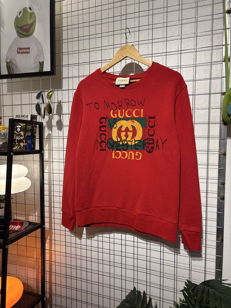 Gucci 'Tomorrow is Yesterday' Red Sweatshirt (Category: Coats, Jackets and Outerwear) located in Cavite. Submitted by vlblgrmnts_ (Listing ID 1466067454, Image 2). Description: Gucci - P-269 20x26 Bestfit Large 9/10 CR 900 - Authentic Gucci red sweatshirt - Features distressed graphics and handwritten 'To morrow Gucci is yesterday' text - Iconic green and red web logo patch on the front - Classic crewneck with ribbed cuffs and hem - Regular fit d