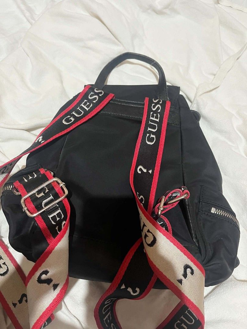 Guess Black Nylon Backpack with Logo Straps (Category: Backpacks) located in Taguig. Submitted by mikacxz (Listing ID 1466059117, Image 3). Description: - Brand: Guess - Material: Durable black nylon - Design: Striking red and white logo straps - Preloved / used but still in good and usable condition. - All compartments and zippers are functional. - Has minor signs of use; please manage expectations and see photos for actual condition. RFS: Declu