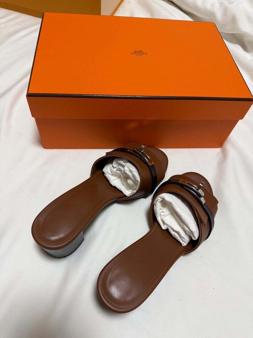 Hermes Brown Leather Sandals with Box (Category: Sneakers & Footwear) located in Cainta. Submitted by jtc23 (Listing ID 1466147261, Image 1). Description: - Brand: Hermes - Style: Open-toe slip-on sandals with metal buckle and block heel - Color: Rich brown - Condition: Clean leather uppers and soles, ready to wear - Inclusions: Original orange Hermes box with white tissue stuffing HERMÈS Gigi 50 Sandals | Size 37.5 High heel sandals in calfskin 