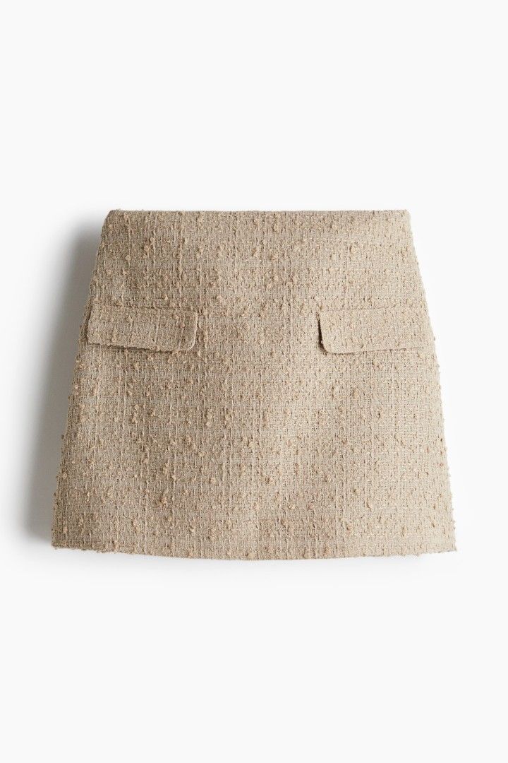 H&M Beige tweed mini skirt with pockets (Category: Skirts) located in Quezon City. Submitted by corrnic (Listing ID 1466061549, Image 1). Description: - Style: Beige textured tweed mini skirt with structured A-line fit - Details: Front flap pockets on both sides and back darts for a flattering shape - Measurements: Waist approx. 15.5 inches across, Length approx. 15 inches - Versatility: Neutral color, easy to match with blouses and basic tops - 