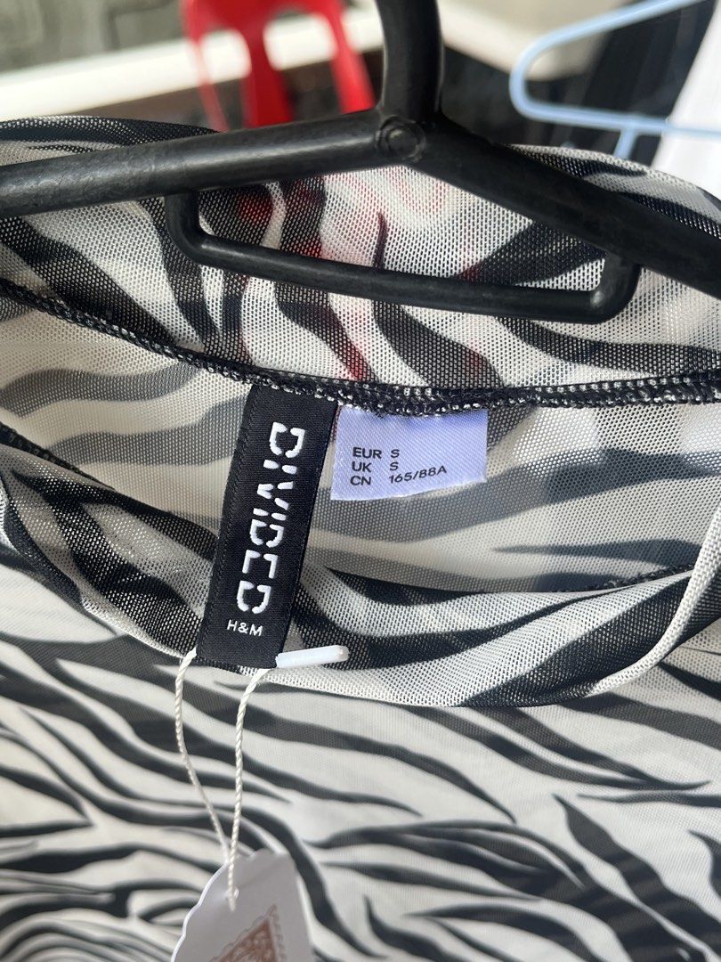 H&M Divided Zebra Print Mesh Top (Category: Sleeveless) located in Dinalupihan. Submitted by penaflorcj (Listing ID 1466011564, Image 2). Description: - Brand: H&M Divided - Pattern: Black and white zebra print - Style: Mock neck, long sleeves, sheer fabric - Size: Small (EUR S, UK S, CN 165/88A) - Perfect for layering or statement night-out looks.