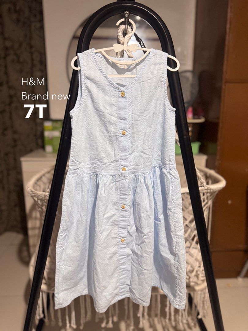 H&M Light Blue Textured Dress Size 7T (Category: Babies & Kids Fashion) located in Santa Rosa. Submitted by yasss23 (Listing ID 1465990838, Image 1). Description: - Brand: H&M - Color: Light Blue - Size: 7T - Material: Textured seersucker fabric - Features: Sleeveless, V-neckline, front buttons, and gathered flared waist - Condition: Brand new with a small tear as pictured.