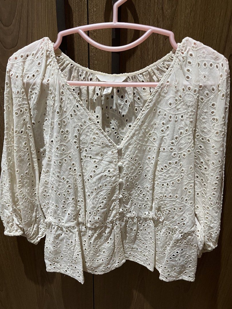 H&M White Eyelet Embroidered Blouse Size M (Category: Blouses) located in Quezon City. Submitted by epictiger.c6451a (Listing ID 1465964220, Image 1). Description: - Brand: H&M - Size: M (fits true to size) - Color: White - Design: V-neck with front buttons, all-over floral eyelet embroidery, and a peplum hem - Sleeves: Three-quarter length with elastic cuffs - Fabric: Lightweight and breathable - Condition: Excellent, clean with no stains or dam
