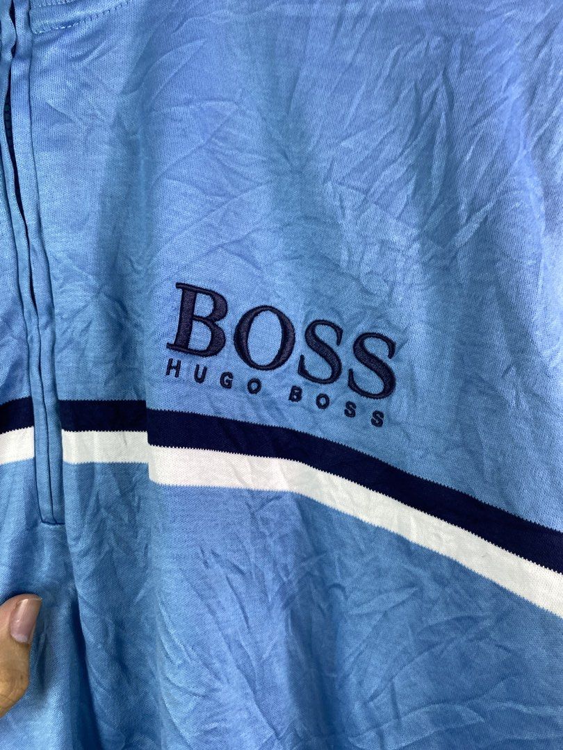 Hugo Boss Light Blue Quarter Zip Sweatshirt (Category: Coats, Jackets and Outerwear) located in Manila. Submitted by declutterpromax (Listing ID 1466027577, Image 2). Description: - Brand: Hugo Boss - Color: Light blue with navy and white chest stripes - Details: Quarter-zip with embroidered logo on the front - Flaws: Has a few small holes, general fabric wear, and a small green square patch near the hem - Note: Grab a bargain if you do not mind 