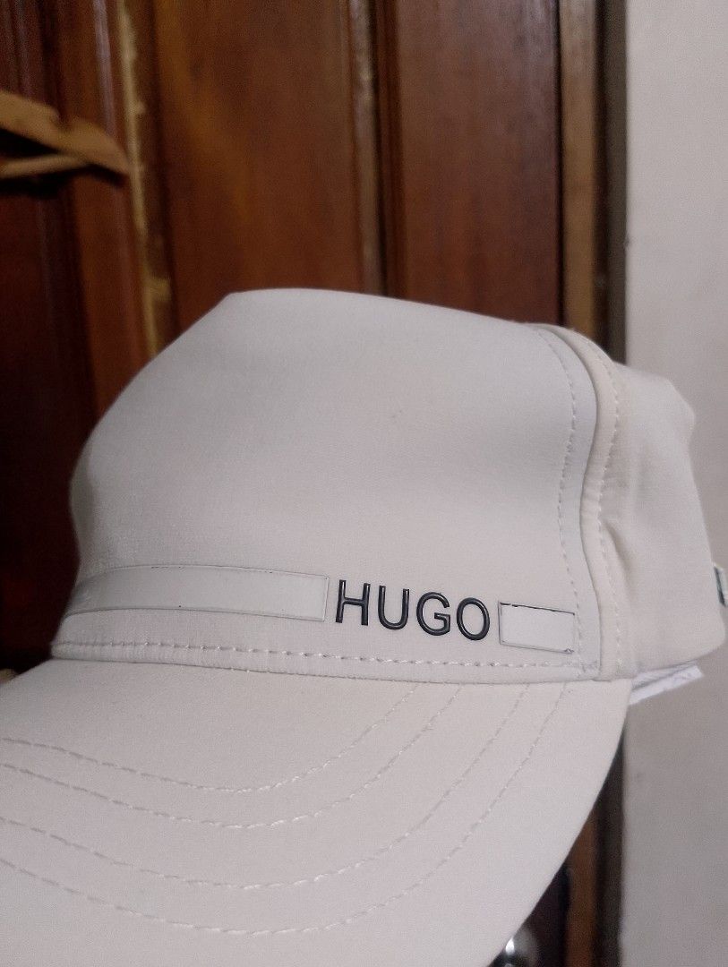HUGO BOSS White Baseball Cap (Category: Caps & Hats) located in Manila. Submitted by thriftyboyzzz (Listing ID 1466110199, Image 2). Description: - Brand: Hugo Boss - Color: Classic White - Design: HUGO logo on front, BOSS branding on the side - Interior: Features repeating BOSS logo print on lining - Closure: Adjustable strap with metal clasp for a custom fit - Condition: Brand new / Excellent - Style: Clean, versatile look that matches any casu