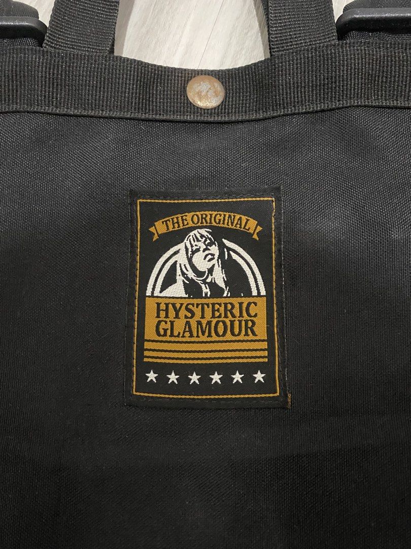 Hysteric Glamour Black Canvas Backpack U.S. 1975 (Category: Backpacks) located in Manila. Submitted by hell_market (Listing ID 1466118331, Image 3). Description: - Brand: Hysteric Glamour - Material: Sturdy black canvas with a clean structured bottom - Design: Front patch reading 'The Original Hysteric Glamour' with stars and 'U.S. 1975 I FEEL LIKE YOU DO' print - Comfort: Sturdy top carry handles and adjustable shoulder straps with durable hardw