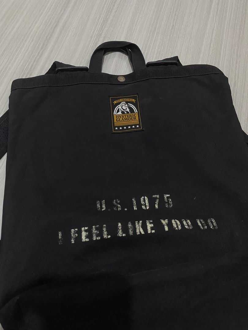 Hysteric Glamour Black Canvas Backpack U.S. 1975 (Category: Backpacks) located in Manila. Submitted by hell_market (Listing ID 1466118331, Image 2). Description: - Brand: Hysteric Glamour - Material: Sturdy black canvas with a clean structured bottom - Design: Front patch reading 'The Original Hysteric Glamour' with stars and 'U.S. 1975 I FEEL LIKE YOU DO' print - Comfort: Sturdy top carry handles and adjustable shoulder straps with durable hardw