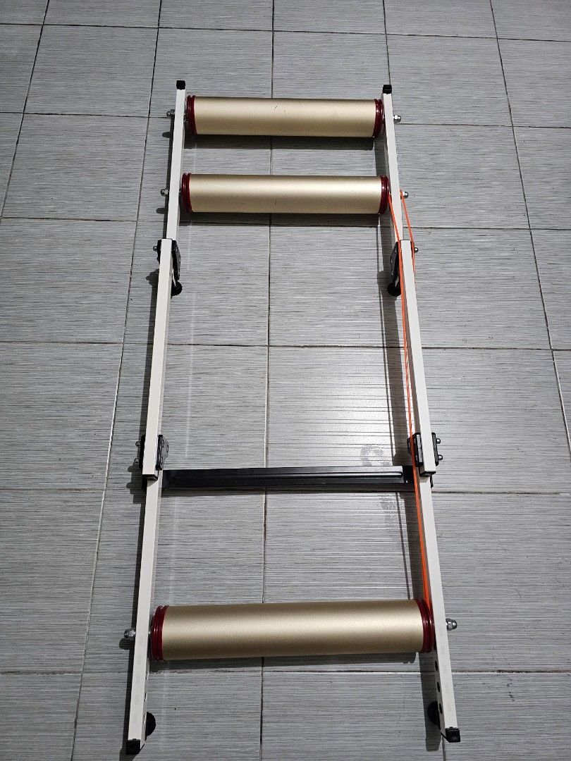 Indoor Bicycle Training Rollers Foldable Bike Trainer (Category: Bicycles) located in Manila. Submitted by john.tulalian (Listing ID 1466125253, Image 1). Description: - Indoor bike rollers for home training and off-season workouts - Three durable aluminum drums with vibrant red ends and orange drive belt - Sturdy white metal frame wit h a foldable design for easy storage - Adjustable wheelbase settings with clear numbered markings - Ideal for ma