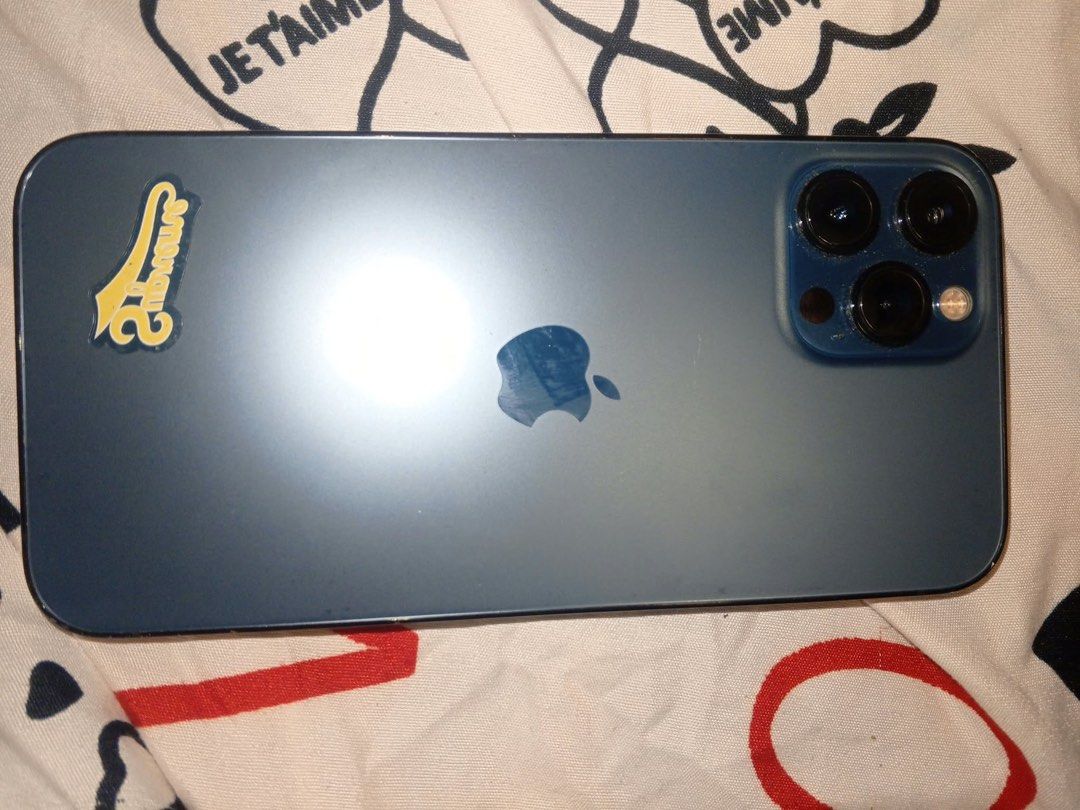 Iphone 12 promax (Category: iPhone 12 Series) located in Baguio. Submitted by nileh (Listing ID 1466077096, Image 2). Description: - Model: iPhone 12 Pro Max - Color: Pacific Blue - Storage Capacity: 256GB - Battery Health: 75% (Service recommended) - Condition: Good physical condition, includes decorative sticker on the back panel - Transaction Method: Meetup if Baguio, Shipping if outside Baguio.