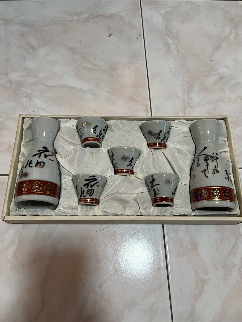 Japan kutani sake set (Category: Other Kitchenware & Tableware) located in Manila. Submitted by rlab_japan_thrift (Listing ID 1466056586, Image 1). Description: Japanese Vintage Kutani Crackle Glaze Sake Set (7 Pieces) 🍶✨ An authentic Japanese ceramic sake set featuring a fine crackle glaze finish (Kanni), hand-painted calligraphy, and gold-accented floral borders around the base. Comes complete in its original satin-lined gift presentation box!