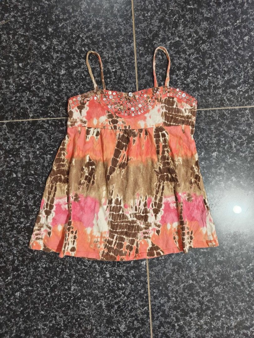 Justice Tie-Dye Sequin Camisole Tank Top (Category: Sleeveless) located in Manila. Submitted by sunnysideup.tree (Listing ID 1466028511, Image 1). Description: Justice camisole top in vibrant tie-dye print. Orange, brown, and pink colorway with white contrast patches. Scoop neckline decorated with metallic sequins and beads. Spaghetti straps. Flowy, relaxed fit through the body. Tag size 10 inside the collar. Soft cotton blend material, breathabl