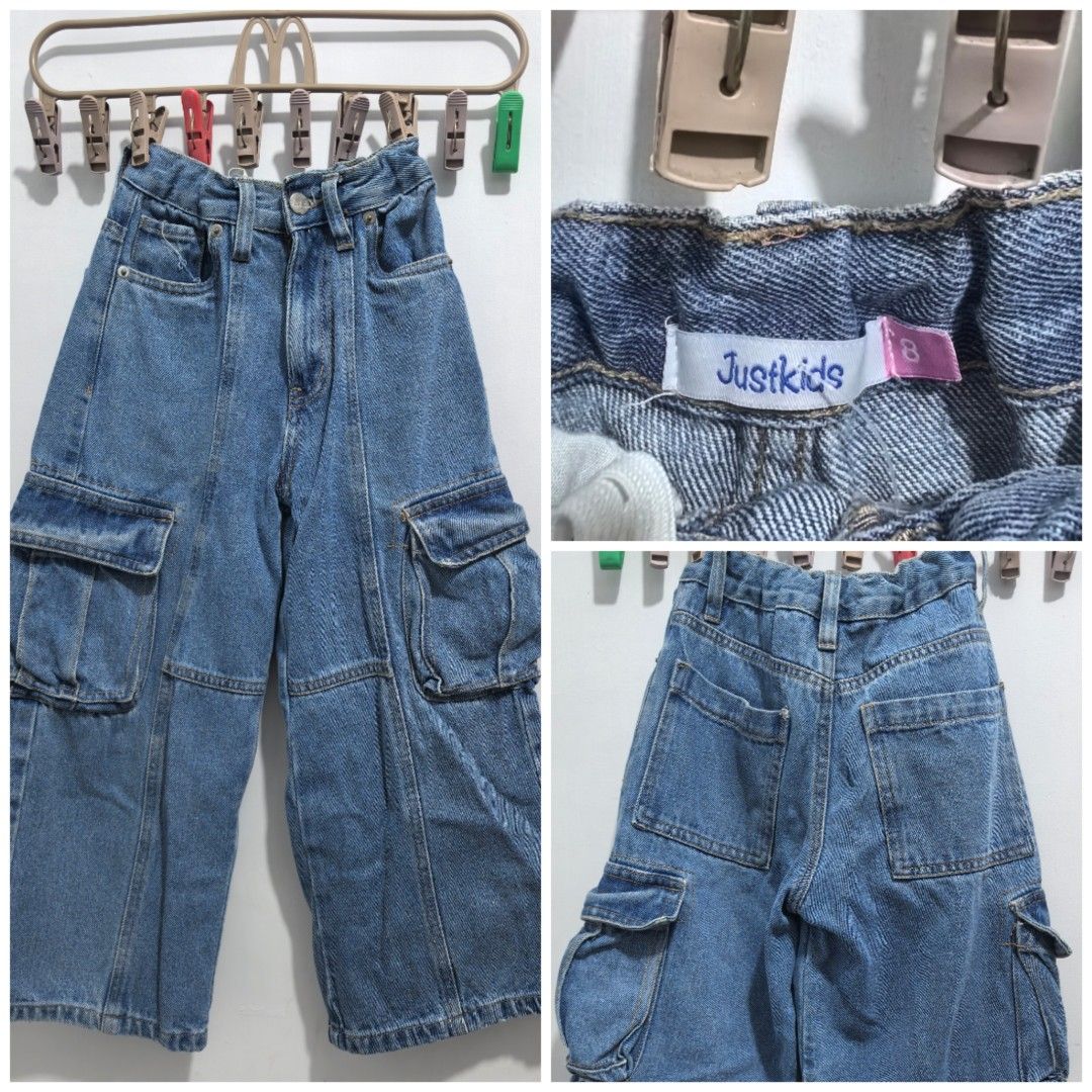 Justkids Denim Cargo Pants Size 8 (Category: Babies & Kids Fashion) located in Pasay City. Submitted by lovedonceee (Listing ID 1466065230, Image 1). Description: - Brand/Model: Justkids Denim Cargo Pants - Size: Tag 8 inside waistband - Color/Wash: Medium blue with classic contrast stitching - Pockets: Large utility cargo pockets on sides and back patch pockets - Fit: Relaxed wide leg cut with structured front panel seams - Details: Waistband eq