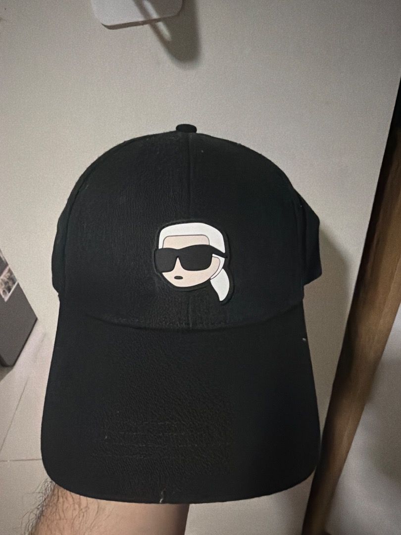 Karl Lagerfeld Black Baseball Cap with Iconic Patch (Category: Caps & Hats) located in Makati City. Submitted by limarhermis (Listing ID 1466144978, Image 1). Description: - Brand: Karl Lagerfeld - Color: Solid Black - Design: Signature cartoon patch on front panel - Structure: Classic curved brim and structured crown - Fit: Adjustable strap closure at the back - Condition: Clean and ready to wear - Style: Great everyday accessory for casual wear