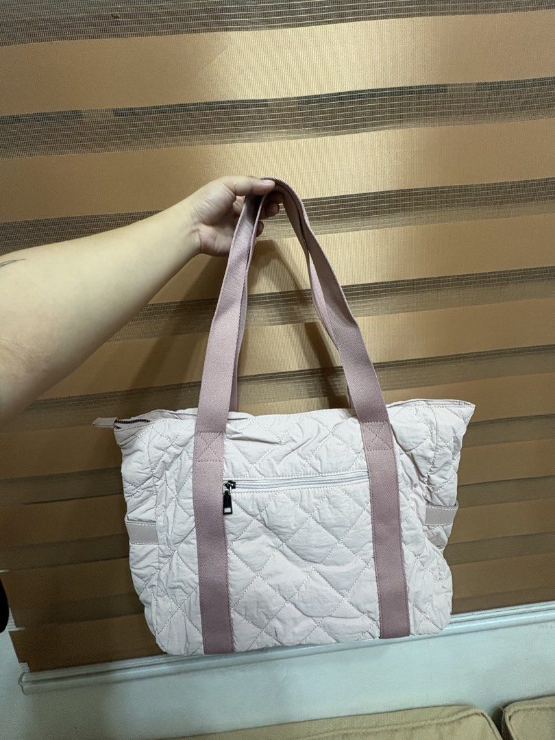 Kasgo Quilted Tote Bag Pink (Category: Tote Bags) located in Manila. Submitted by maemey_botique23 (Listing ID 1466081569, Image 3). Description: Kasgo quilted tote bag in light pink. Quilted nylon material with sturdy pink shoulder straps. Exterior zippered pocket on the front. Fully lined interior with multiple compartments, padded laptop sleeve, and a matching small quilted pouch included. Zipper closure on top. Brand new in original plastic p