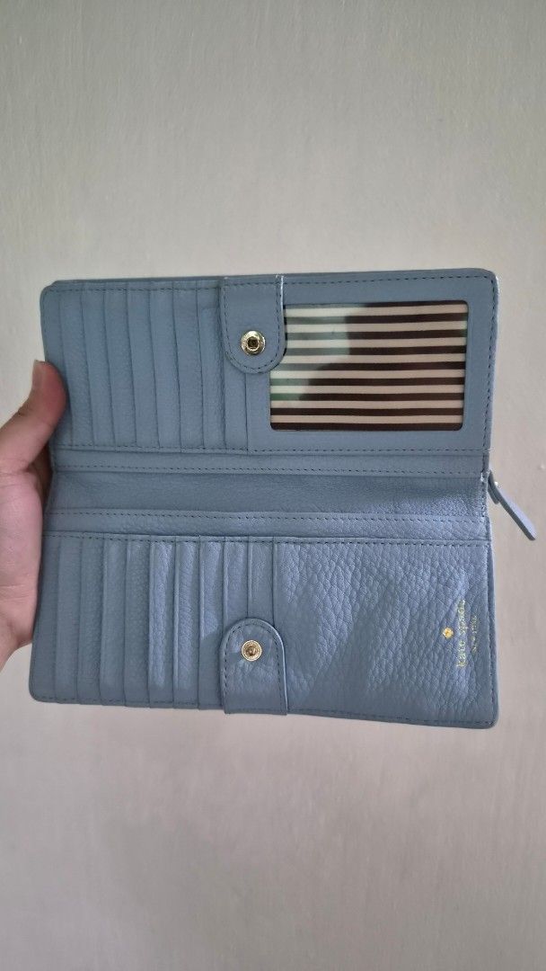 Kate Spade New York Blue Leather Wallet (Category: Wallets & Card holders) located in Quezon City. Submitted by classique.carry_alls (Listing ID 1465974474, Image 2). Description: - Brand: Kate Spade New York - Material: Premium light blue pebbled leather - Hardware: Elegant gold-tone accents and front/interior lettering - Closure: Secure fold-over snap closure - Interior: Multiple card slots, clear ID window, and chic striped lining - Extra Feat