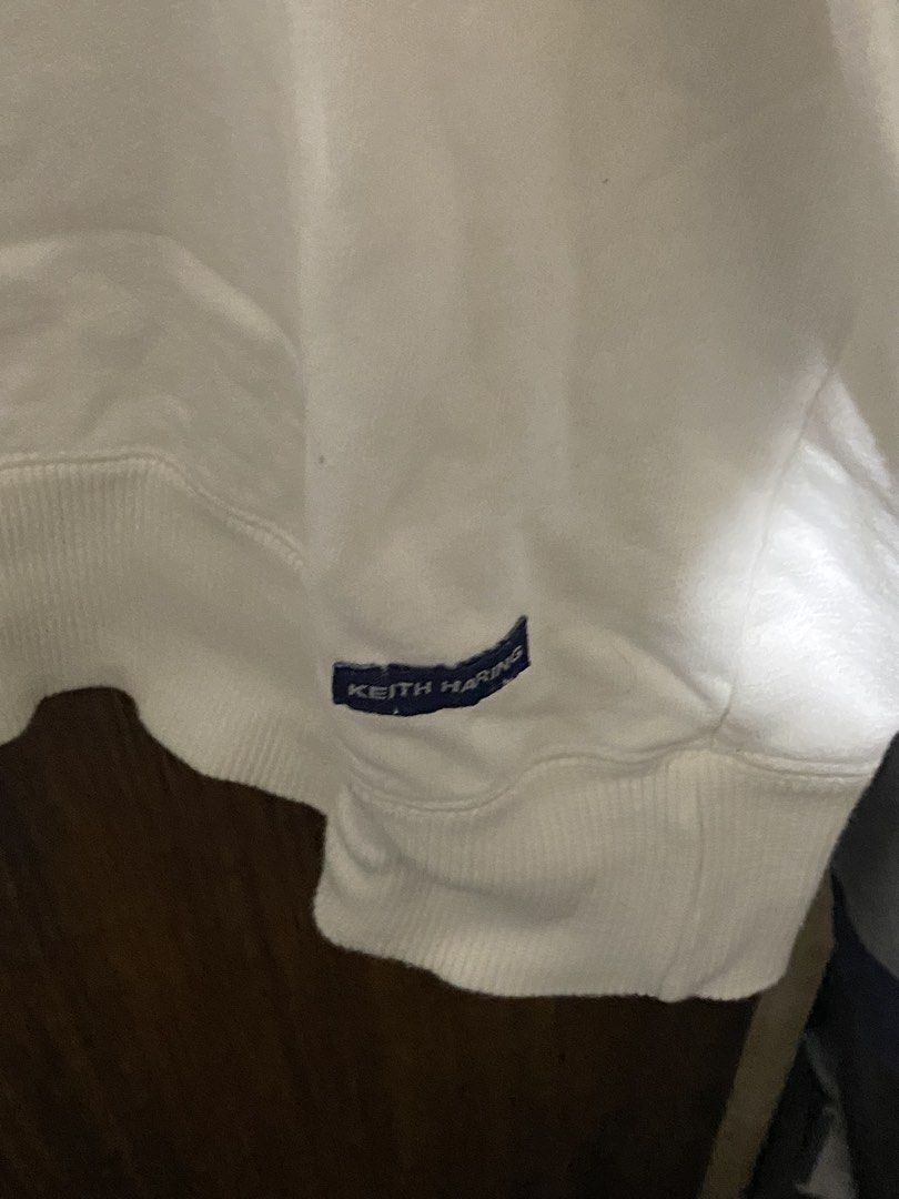 Keith Haring US Flag White Sweatshirt (Category: Coats, Jackets and Outerwear) located in Imus. Submitted by frootiloots4103 (Listing ID 1466033689, Image 2). Description: - Authentic Keith Haring collection white sweatshirt - Eye-catching front graphic featuring the American flag and signature dancing figures - 25x28 - Subtle embroidered Keith Haring branding tag at the bottom hem and back collar - Classic clean look with comfortable ribbed cuff