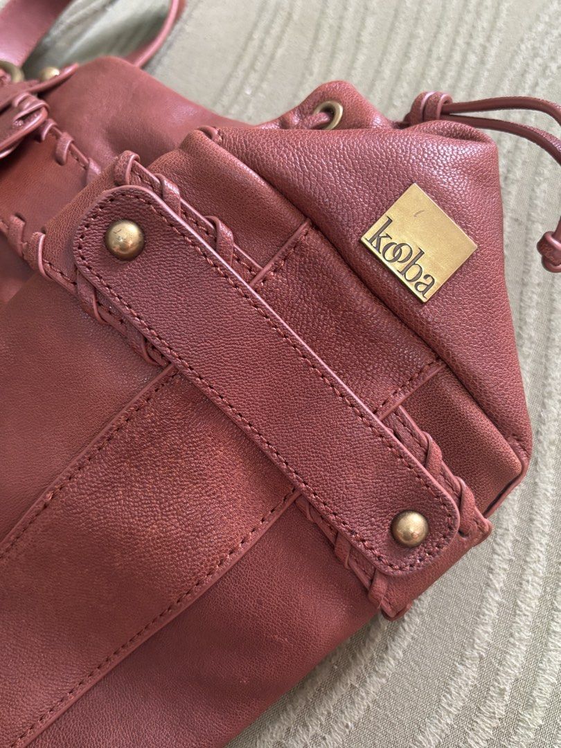 KOOBA Brown Leather Shoulder Bag with Brass Hardware (Category: Shoulder Bags) located in Batangas. Submitted by missraee (Listing ID 1466004334, Image 2). Description: LIKE NEW! Super nice leather material - Color/Material: Rich reddish brown leather with earthy tones - Straps: Double shoulder straps with sturdy round brass rings - Details: Unique laced strap design on front panels with brass rivets and eyelets - Interior: Roomy main compartment