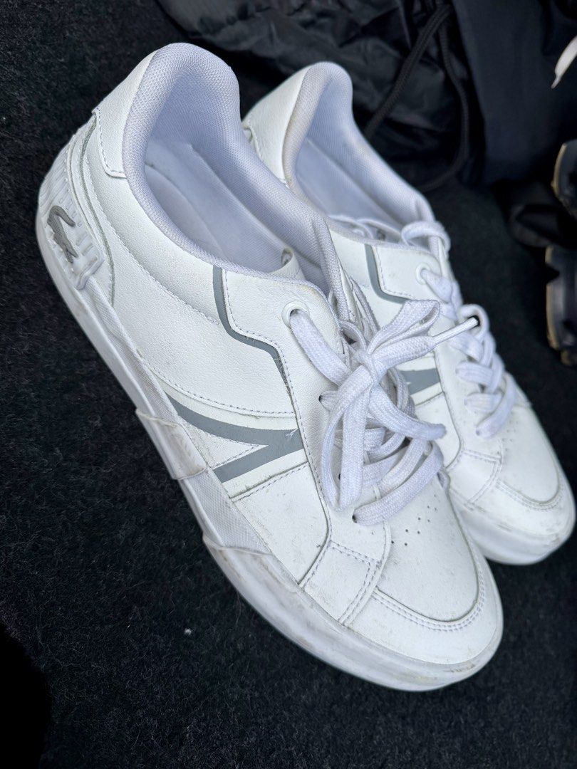 Lacoste L004 White Sneakers Size 8.5 (Category: Sneakers) located in Manila. Submitted by miggy069 (Listing ID 1465984580, Image 1). Description: - Brand: Lacoste L004 - Color: White with grey accent stripes - Size: US 8.5 / UK 7.5 / EUR 41 - Details: Traditional lace-up front, embossed croc logo on heel, textured white rubber cupsole - Condition: General wear on leather uppers and minor scuffs on midsoles from regular use - Cleanliness: Clean in