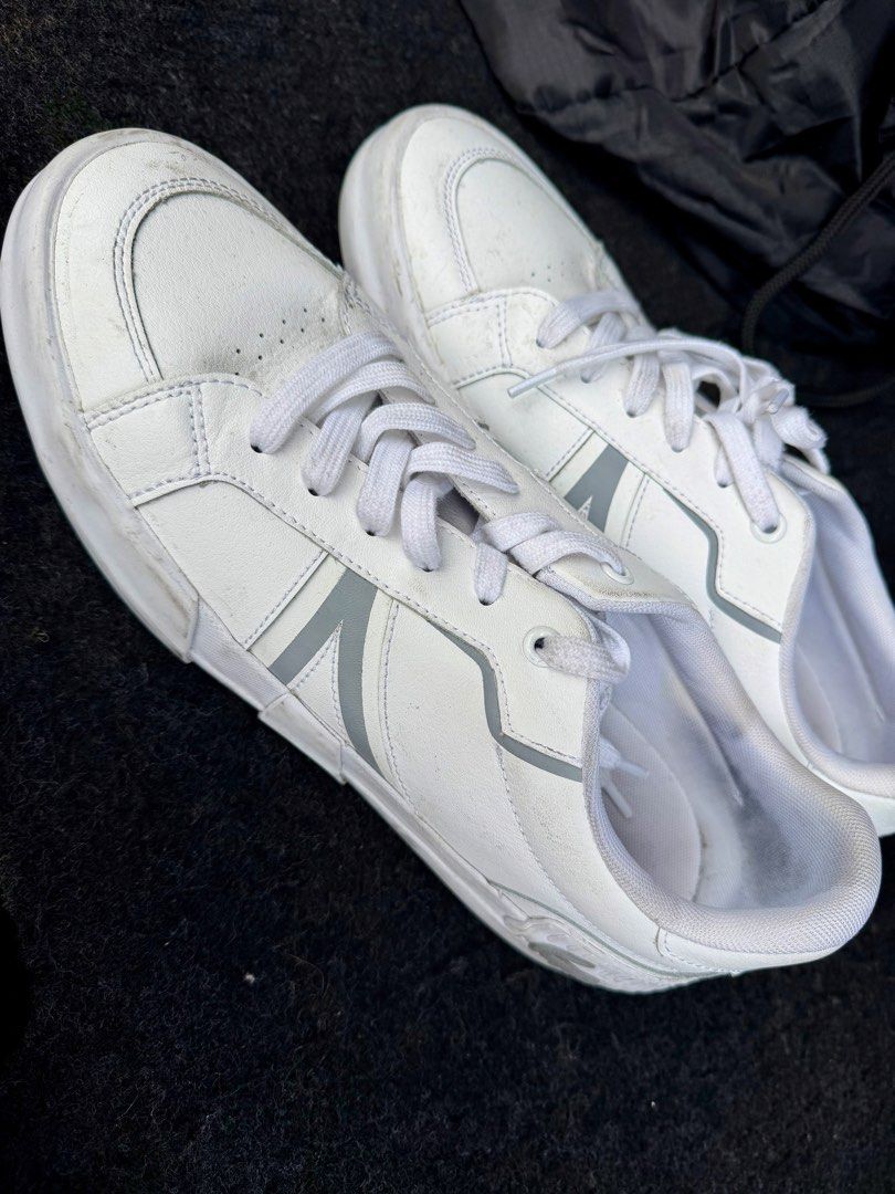 Lacoste L004 White Sneakers Size 8.5 (Category: Sneakers) located in Manila. Submitted by miggy069 (Listing ID 1465984580, Image 2). Description: - Brand: Lacoste L004 - Color: White with grey accent stripes - Size: US 8.5 / UK 7.5 / EUR 41 - Details: Traditional lace-up front, embossed croc logo on heel, textured white rubber cupsole - Condition: General wear on leather uppers and minor scuffs on midsoles from regular use - Cleanliness: Clean in