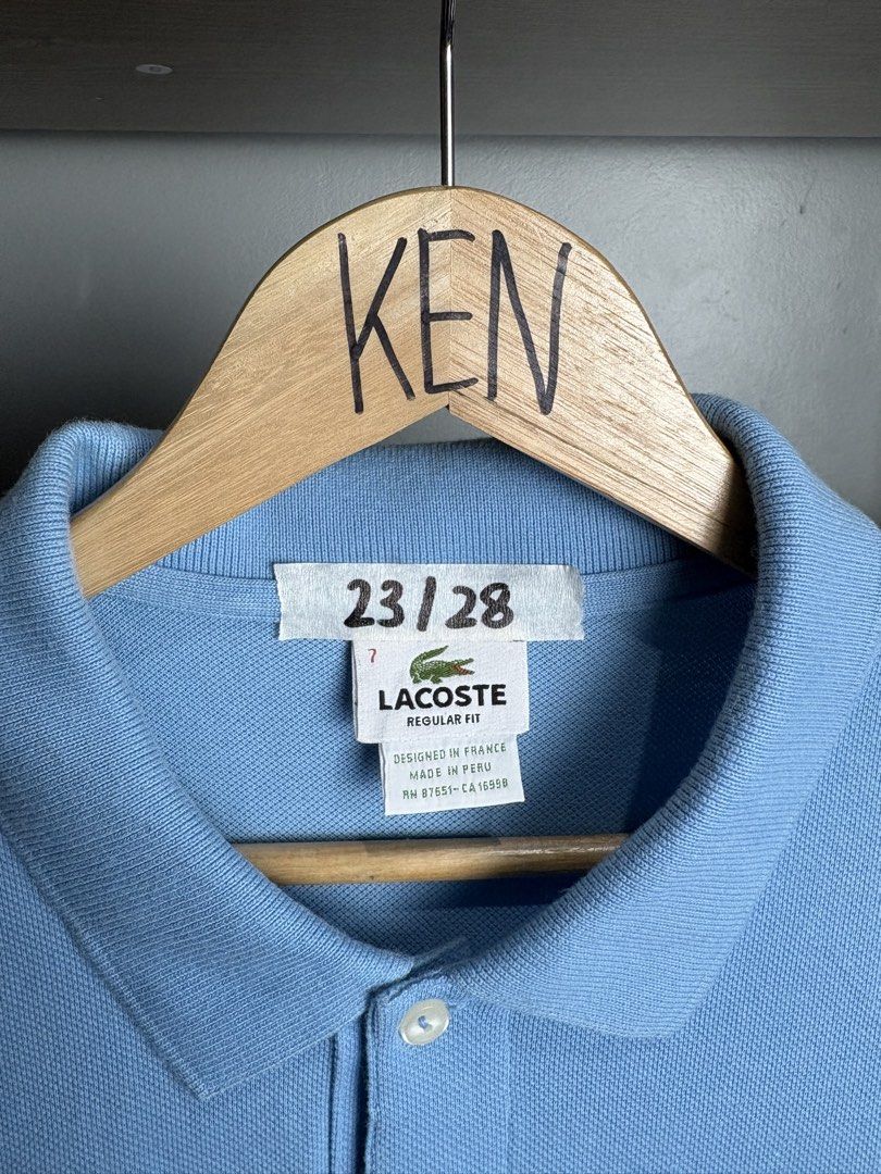 Lacoste Light Blue Regular Fit Polo Shirt Size 7 (Category: Tshirts & Polo Shirts ) located in Manila. Submitted by thriftnikenv.2 (Listing ID 1465991015, Image 3). Description: - Brand: Lacoste - Color: Light Blue - Fit: Regular Fit - Size: Tag 7 - Material: 100% Cotton (Made in Peru) - Details: Two-button placket with white buttons, iconic embroidered green crocodile logo, ribbed short sleeve cuffs - Condition: Clean collar and solid stitching 