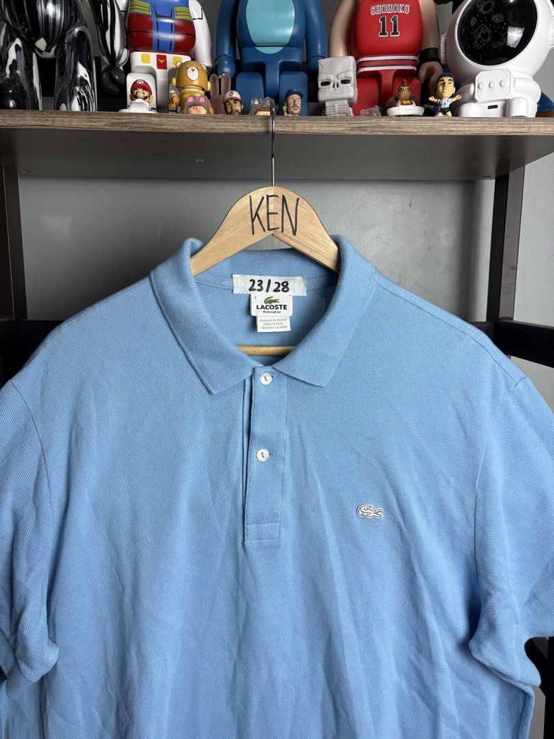 Lacoste Light Blue Regular Fit Polo Shirt Size 7 (Category: Tshirts & Polo Shirts ) located in Manila. Submitted by thriftnikenv.2 (Listing ID 1465991015, Image 2). Description: - Brand: Lacoste - Color: Light Blue - Fit: Regular Fit - Size: Tag 7 - Material: 100% Cotton (Made in Peru) - Details: Two-button placket with white buttons, iconic embroidered green crocodile logo, ribbed short sleeve cuffs - Condition: Clean collar and solid stitching 