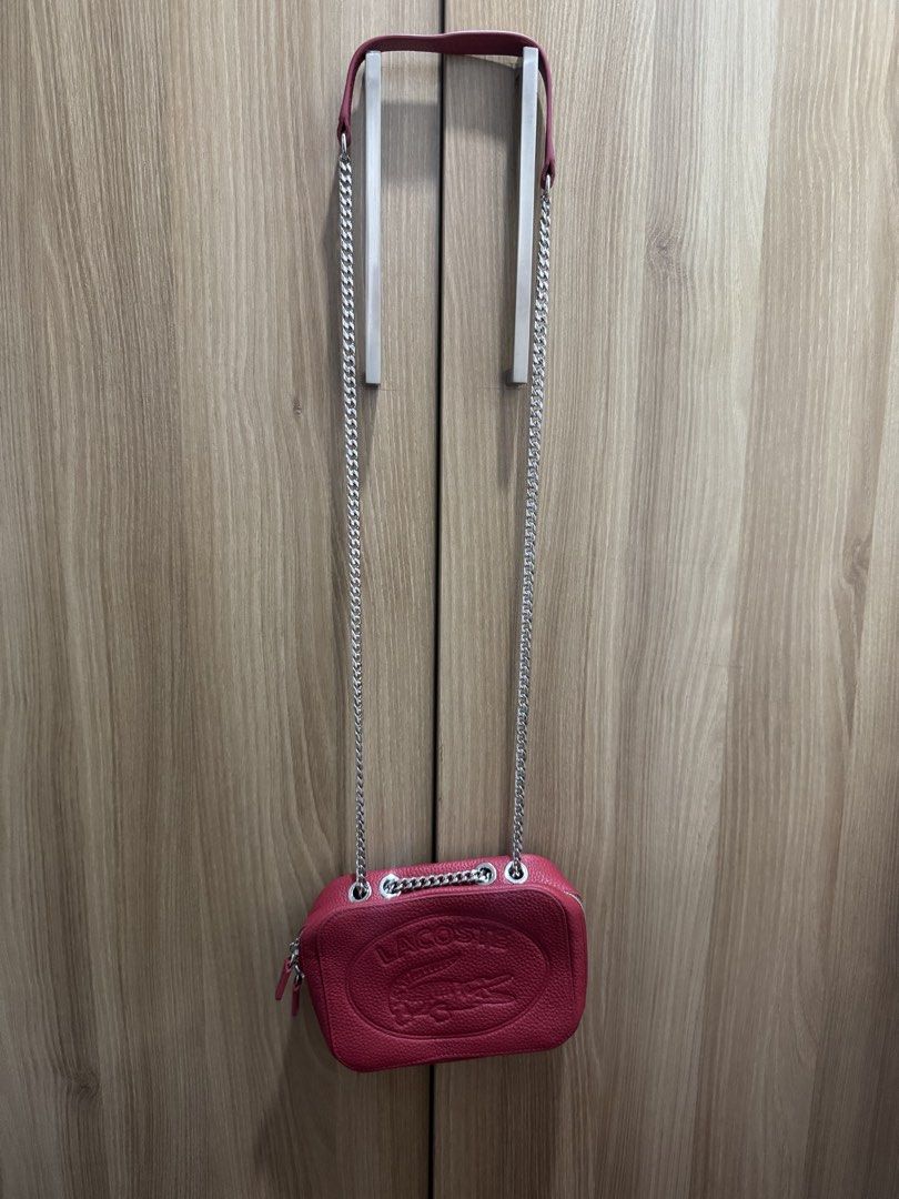Lacoste Red Leather Crossbody Bag with Chain Strap (Category: Cross-body Bags) located in Manila. Submitted by prelovemd (Listing ID 1466040845, Image 2). Description: - Authentic Lacoste red pebble-grain leather bag - Bold large embossed crocodile logo on the front - Chic silver-tone chain strap with a comfortable leather shoulder guard - Secure zip closure with convenient double zipper pulls - Red fabric-lined interior complete with a slip pock