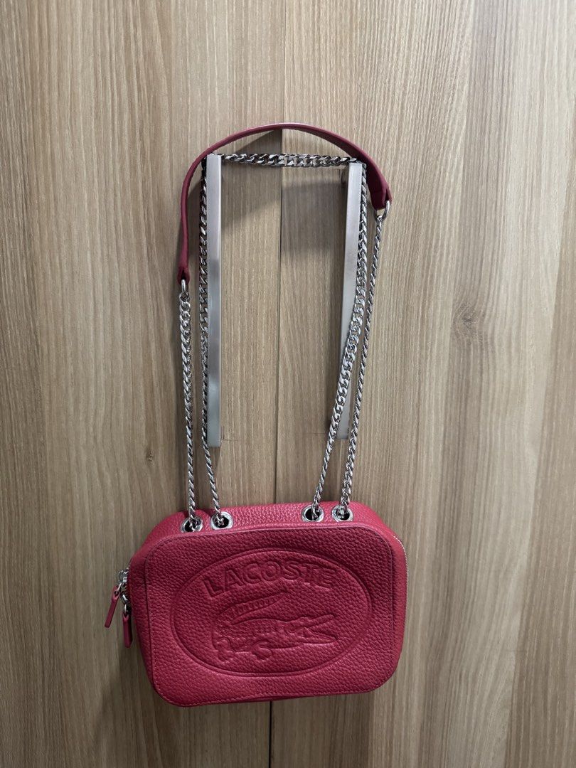 Lacoste Red Leather Crossbody Bag with Chain Strap (Category: Cross-body Bags) located in Manila. Submitted by prelovemd (Listing ID 1466040845, Image 3). Description: - Authentic Lacoste red pebble-grain leather bag - Bold large embossed crocodile logo on the front - Chic silver-tone chain strap with a comfortable leather shoulder guard - Secure zip closure with convenient double zipper pulls - Red fabric-lined interior complete with a slip pock