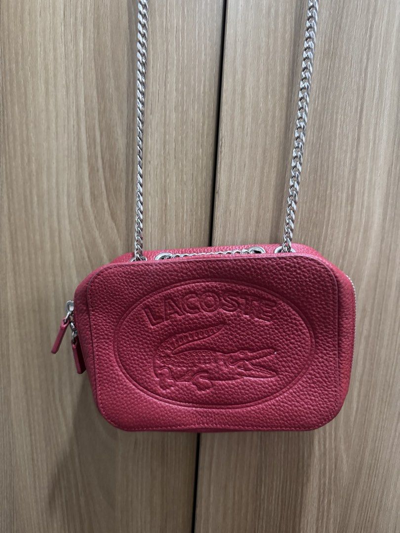 Lacoste Red Leather Crossbody Bag with Chain Strap (Category: Cross-body Bags) located in Manila. Submitted by prelovemd (Listing ID 1466040845, Image 1). Description: - Authentic Lacoste red pebble-grain leather bag - Bold large embossed crocodile logo on the front - Chic silver-tone chain strap with a comfortable leather shoulder guard - Secure zip closure with convenient double zipper pulls - Red fabric-lined interior complete with a slip pock