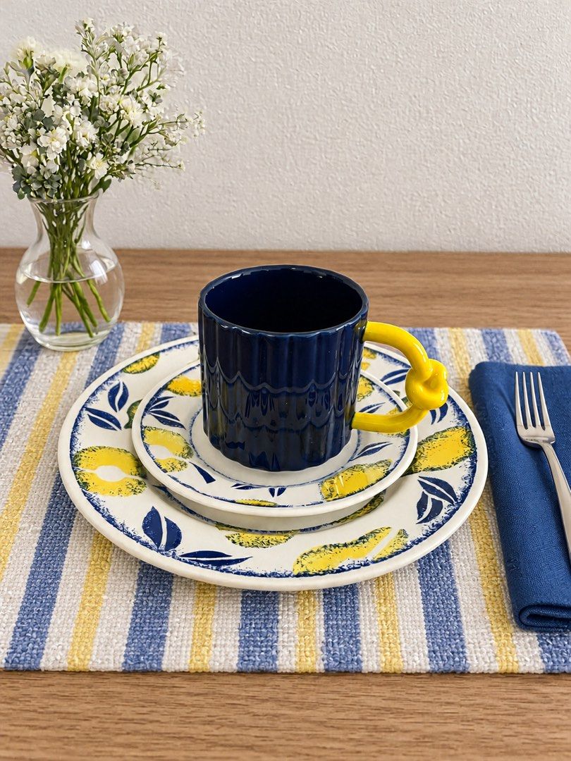 Lemon Pattern Plates and Dark Blue Mug Set (Category: Dinnerware & Cutlery) located in Baguio. Submitted by the_general_store (Listing ID 1466101357, Image 1). Description: - Includes a ceramic dinner plate, side plate, and a matching deep blue mug - Mug features a unique yellow handle with a stylish knotted detail *Dimensions: Navy textured mug with yellow pretzel handle: height 3.5”, rim 3.5”, width w/ handle 5.25” Lemon saucer: width 6.75” Lem