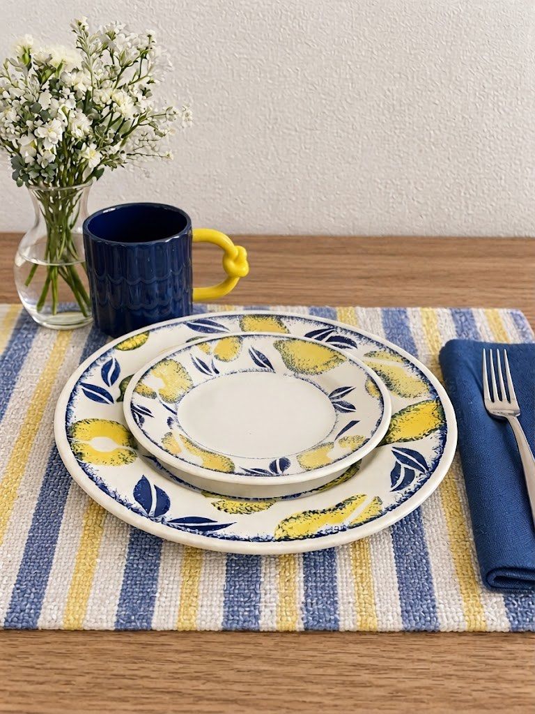 Lemon Pattern Plates and Dark Blue Mug Set (Category: Dinnerware & Cutlery) located in Baguio. Submitted by the_general_store (Listing ID 1466101357, Image 2). Description: - Includes a ceramic dinner plate, side plate, and a matching deep blue mug - Mug features a unique yellow handle with a stylish knotted detail *Dimensions: Navy textured mug with yellow pretzel handle: height 3.5”, rim 3.5”, width w/ handle 5.25” Lemon saucer: width 6.75” Lem