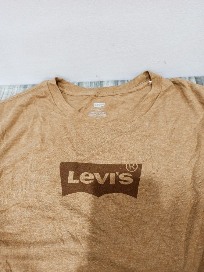 Levi's Tee (Category: Tshirts & Polo Shirts ) located in Tagbilaran City. Submitted by delasierra39181 (Listing ID 1466025082, Image 2). Description: - Brand: Levi's - Color: Brown with heathered texture and darker brown batwing logo - Size: L - Material: Cotton blend - Condition: Great everyday wear with iconic red tab on the sleeve hem - Origin: Made in Pakistan with complete manufacturer and care tags.