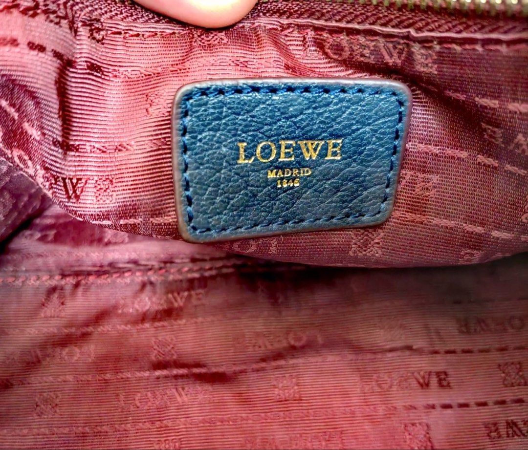 Loewe Blue Leather Amazona bag (Category: Luxury Bags & Wallets) located in Manila. Submitted by junejanuary (Listing ID 1466145374, Image 3). Description: - Loewe blue leather handbag - Striking embossed logo in the center - Elegant gold hardware on handles and strap attachments - Structured shape with chic dark red edge glazing - Double top handles with rectangular loops - Includes matching adjustable leather strap with buckles and clips - Cond